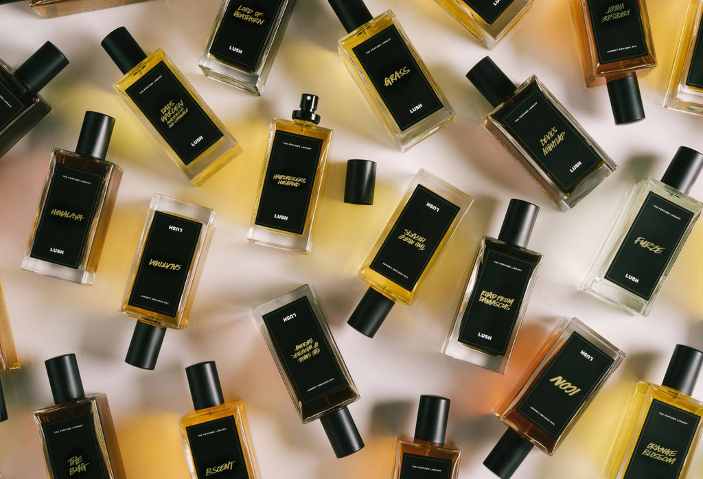 A number of black label perfume bottles are arranged randomly, with Hairdresser's Husband in the centre, lid off.